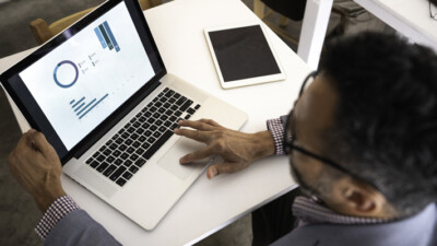 A man looking at charts on a laptop.