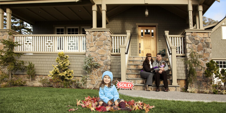 A family in front of their newly purchased home.