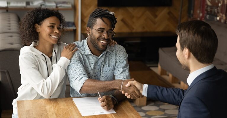 Man and woman shaking hands with businessman.