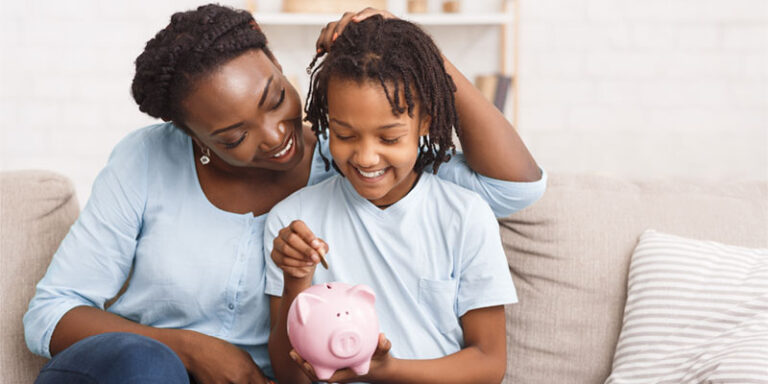 Woman and child putting coins into piggy bank.