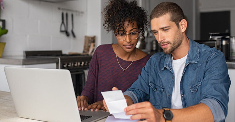 A man and woman reviewing financial documents.