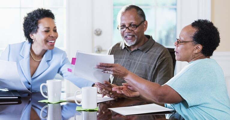 A businesswoman, a man, and a woman going over documents.