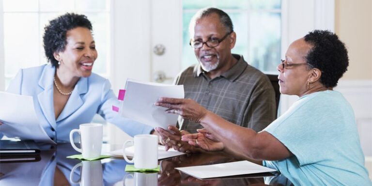 A businesswoman, a man, and a woman going over documents.