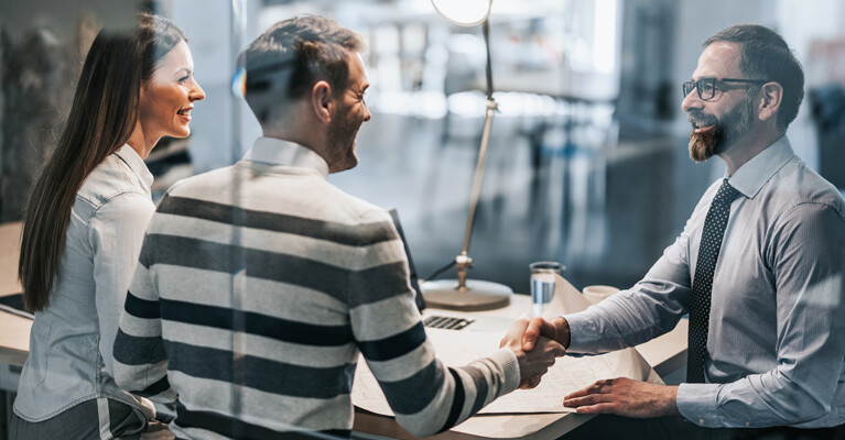 Couple meeting with a businessman, handshake