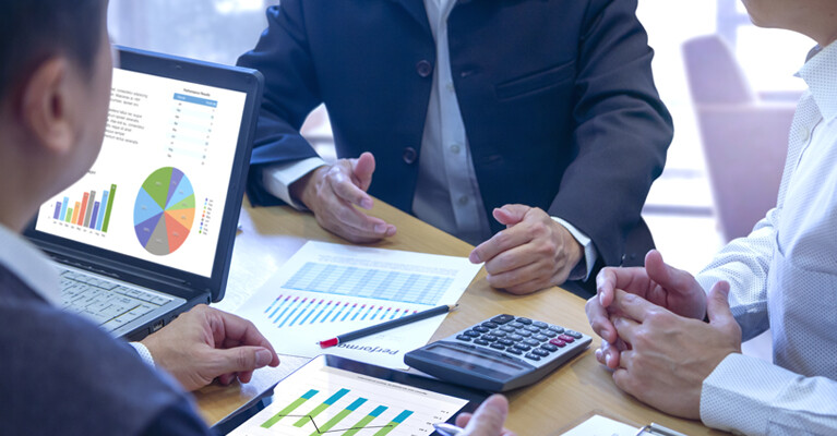 Businessmen looking at graphs and charts.