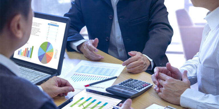 Businessmen looking at graphs and charts.