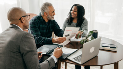 A businessman and a couple reviewing documents.