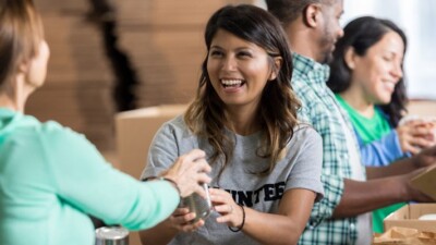 A volunteer passing out food at a food pantry.