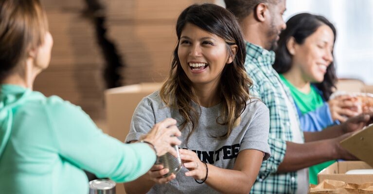 A volunteer passing out food at a food pantry.