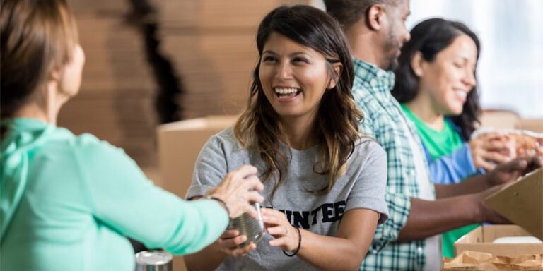 A volunteer passing out food at a food pantry.