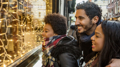 A family happily looks at a holiday window display.
