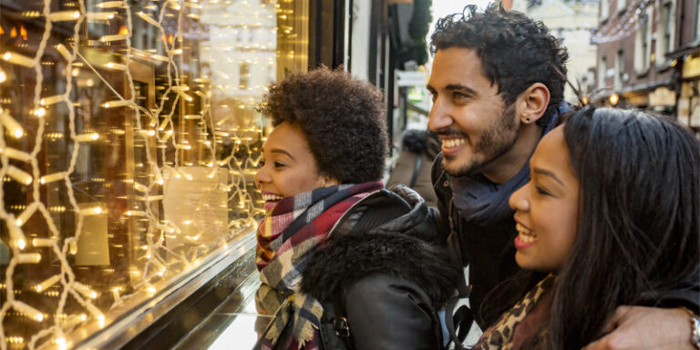A family happily looks at a holiday window display.