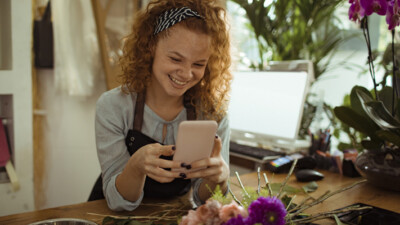 A florist smiling at her phone.