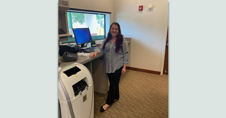 Holly Baker, a WSFS intern, at a bank branch's drive-thru window.