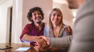 Man and woman shaking hands with businessman.