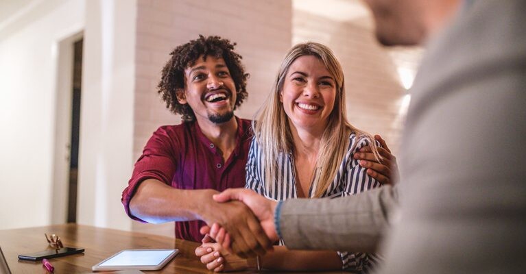 Man and woman shaking hands with businessman.