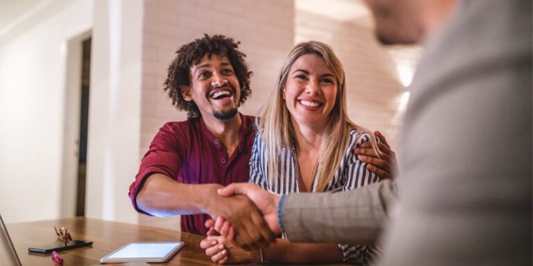 Man and woman shaking hands with businessman.