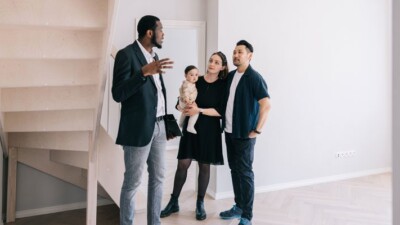 A real estate agent showing a property to a mother, father, and their baby.