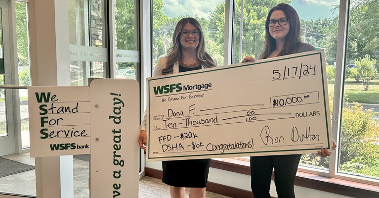 Two people holding a large novelty check.