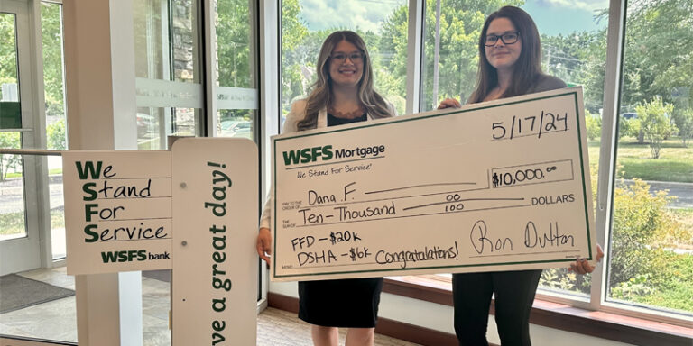 Two people holding a large novelty check.