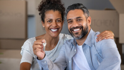 New homeowners holding house keys.