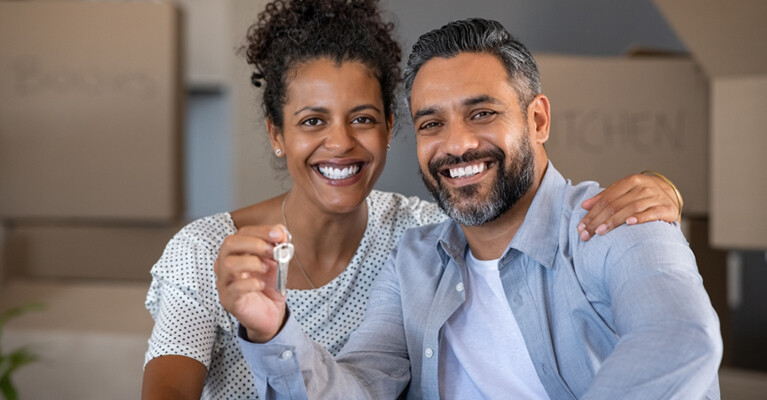 New homeowners holding house keys.