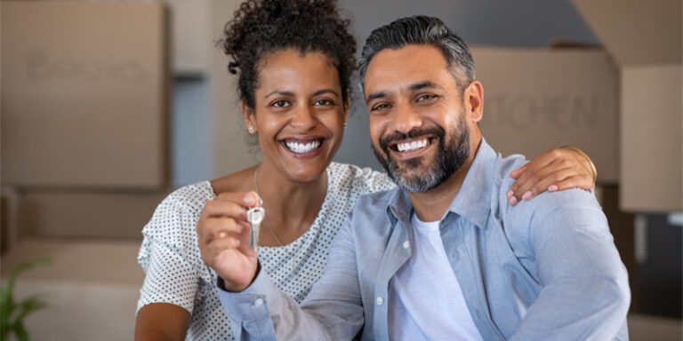 New homeowners holding house keys.