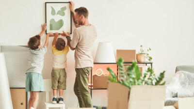 A family hanging a painting.