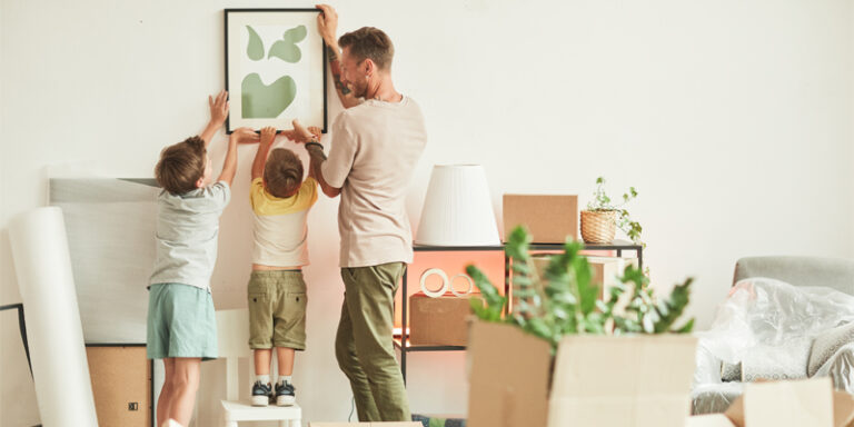 A family hanging a painting.