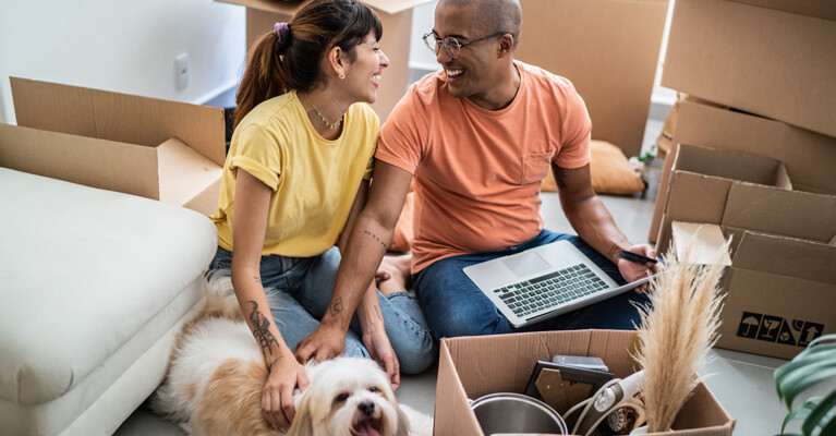 Young couple with dog studying the housing market.