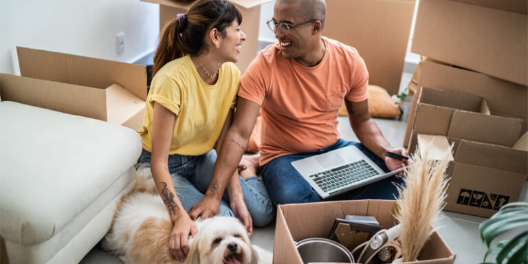 Young couple with dog studying the housing market.