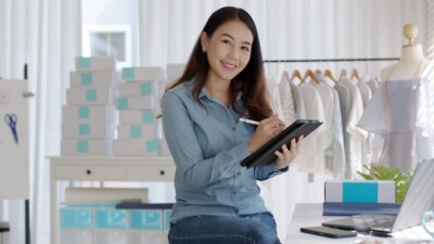 A woman smiling and using a tablet.