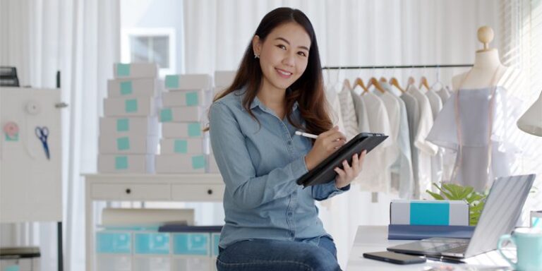 A woman smiling and using a tablet.