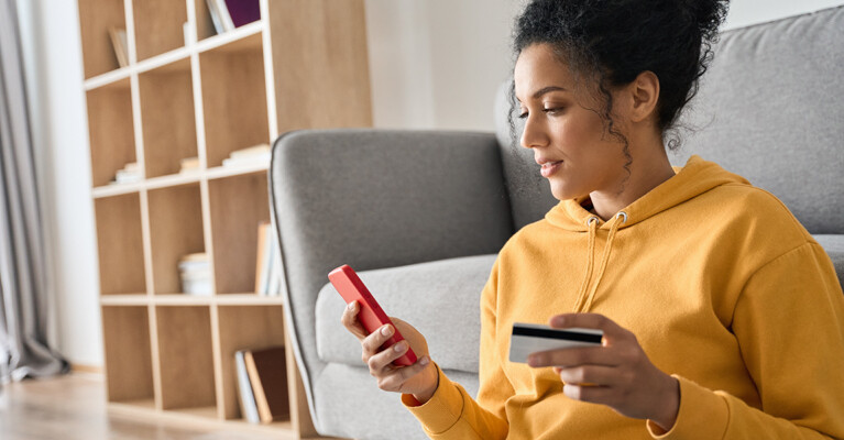 Woman using credit card to purchase something on phone.