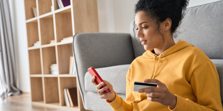 Woman using credit card to purchase something on phone.