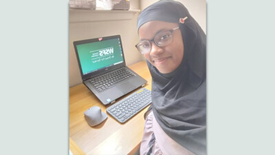 A WSFS intern in front of their computer setup.