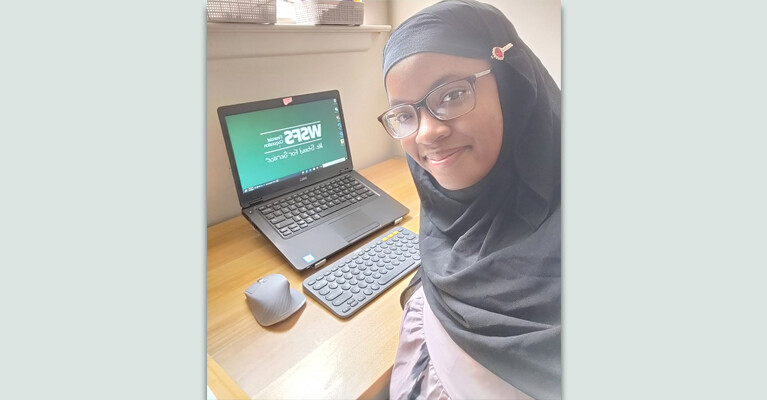 A WSFS intern in front of their computer setup.