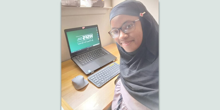 A WSFS intern in front of their computer setup.