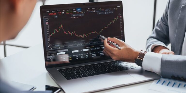 Businessmen looking at stock chart on computer.