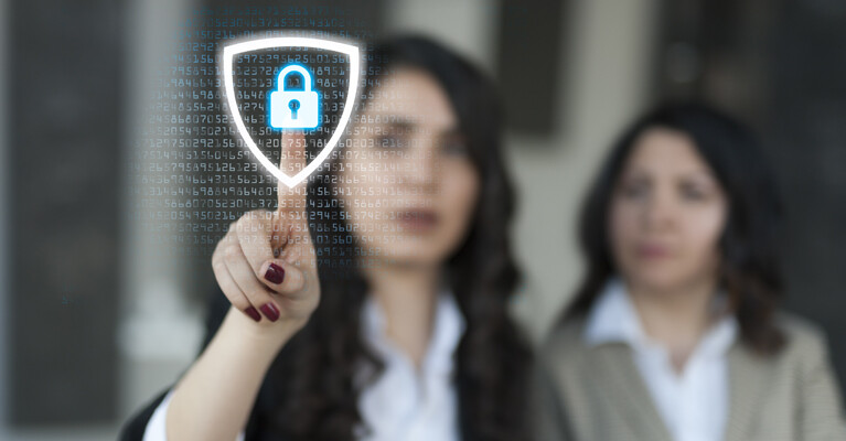 Two women touching a digital security icon.