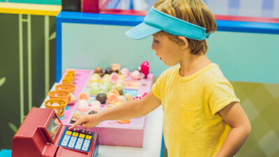 A child playing with a toy cash register.