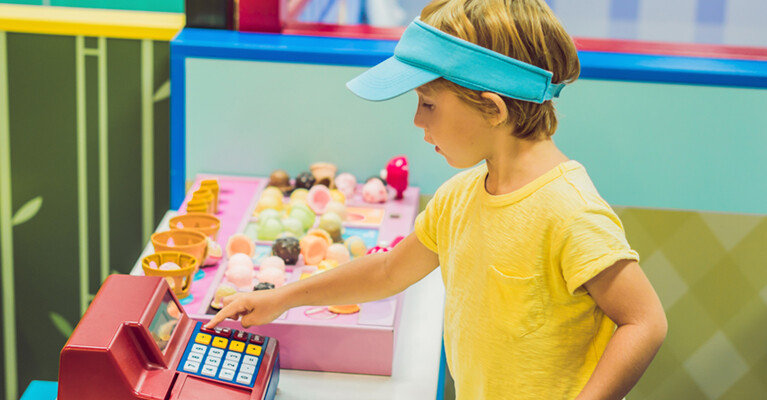 A child playing with a toy cash register.