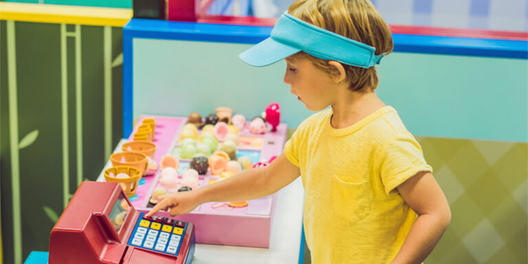 A child playing with a toy cash register.