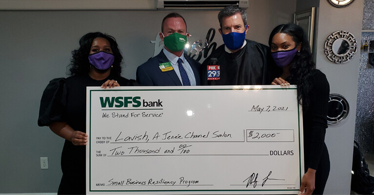 Lavish Salon employees, WSFS Associates, and a Fox 29 news anchor, holding a prop check for $2000.