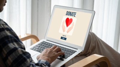A person using a laptop to donate money to a charity.