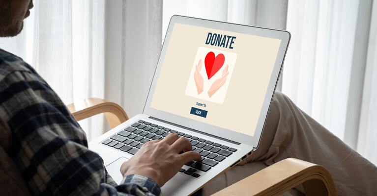 A person using a laptop to donate money to a charity.