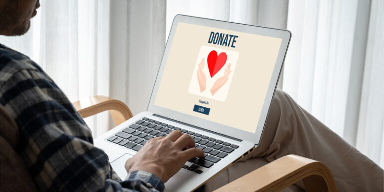A person using a laptop to donate money to a charity.