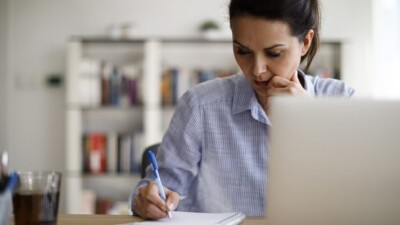 Woman writing in notebook.