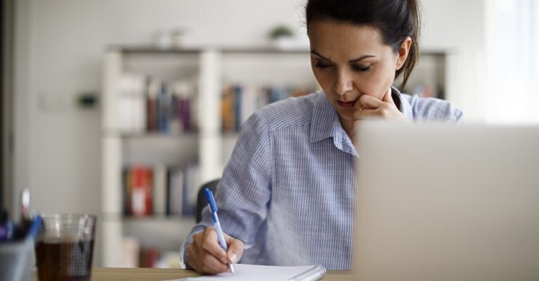 Woman writing in notebook.