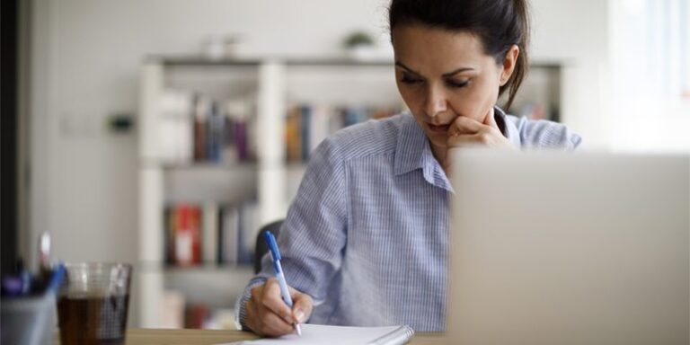 Woman writing in notebook.